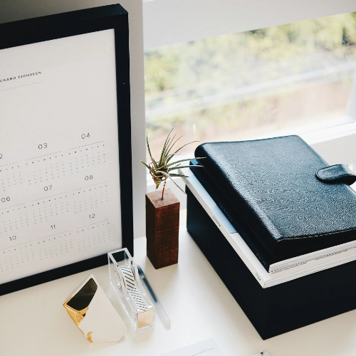 Gesellschaftsgründung rechtssicher gestalten Kalender und Notizbücher auf Schreibtisch - symbolisieren Gesellschaftsgründung mit strukturierter Planung