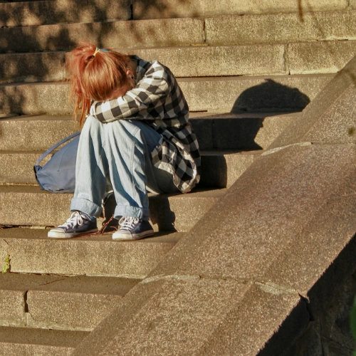 Mobbing und Diskriminierung am Arbeitsplatz: emotionale Belastung sichtbar machen Person hält Hände vor Gesicht - symbolisiert emotionale Belastung durch Mobbing am Arbeitsplatz